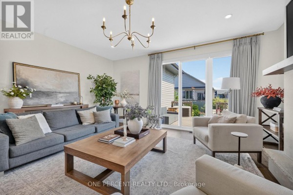 Living room with gray sofa, coffee table, painting, and chandelier - 10 Granite Street Clarence Rockland