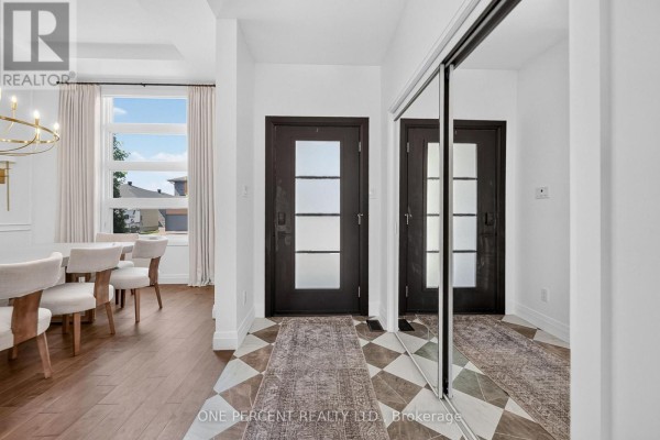 Entrance hallway with dark wood doors, mirrored closets, and a patterned runner. - 10 Granite Street, Clarence Rockland