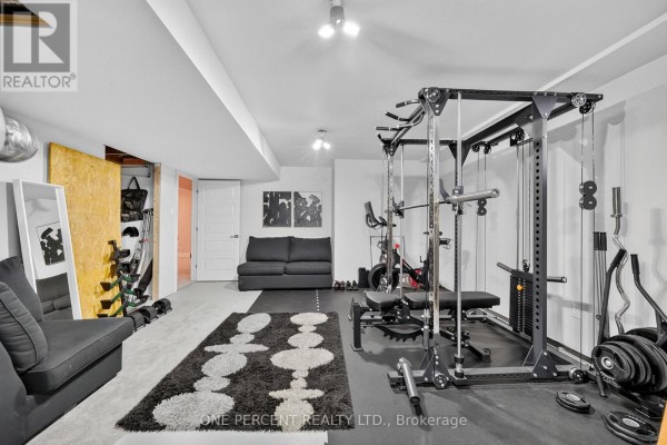 Home gym with power cage, Peloton bike, sofa, and weights - 10 Granite Street Clarence Rockland