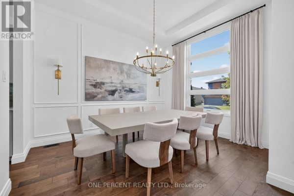 Dining room with a large rectangular table, eight chairs, and a large window. - 10 Granite Street, Clarence Rockland