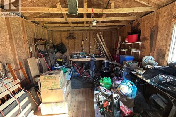 Interior of a wooden shed filled with tools, storage bins, and various equipment. - 10 Hardwicke Road, Hardwicke