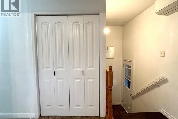 White bi-fold doors open into a hallway with a staircase and a small door. - 10 Hardwicke Road, Hardwicke