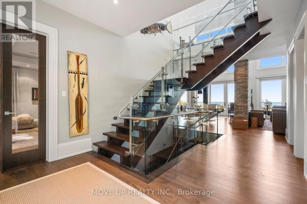 Living room with brown leather sofas, a large wooden coffee table, and a view into the kitchen. - 10 Hiawatha Avenue, Wasaga Beach