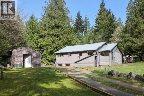 A grey house with a detached wooden shed and a small wooden deck, situated on a green lawn. - 10 Horbury Rd, Cumberland