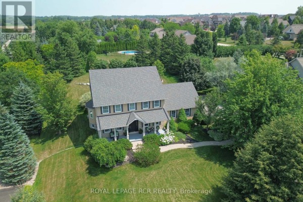 Aerial view of a beige two-story house with dark shutters and manicured landscaping. - 10 Island Lake Road, Mono