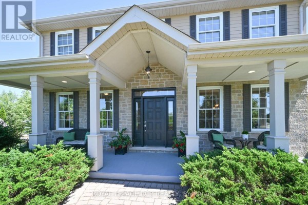Front entrance porch with dark door, stone facade, white columns, and seating. - 10 Island Lake Road, Mono