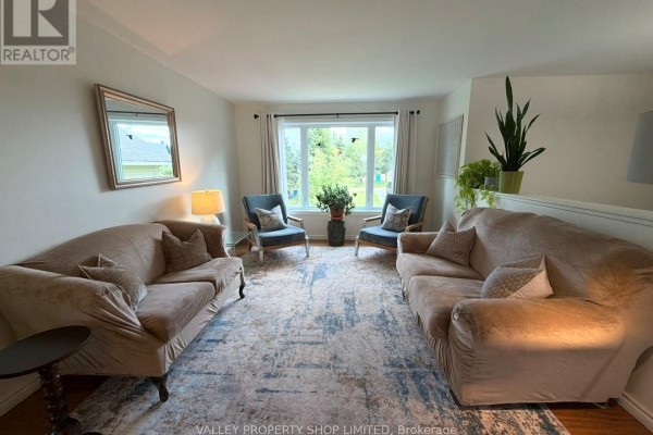 Living room with three sofas, two armchairs, a large window, and a patterned area rug. - 10 Kirk Court, North Algona Wilberforce