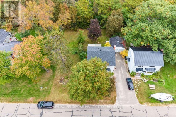 Aerial view of the property showing the house, garage, driveway, and surrounding trees. - 10 Laurier Avenue, Deep River