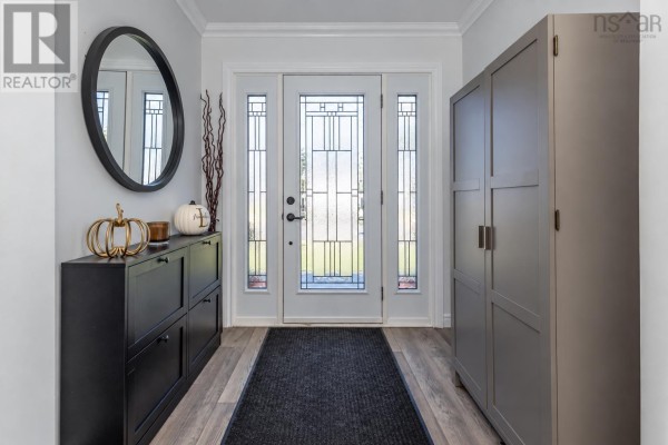 Close-up interior entryway detail with a round mirror, decorative branches, and a glass door with frosted panels. - 10 Melissa Crescent, Sydney