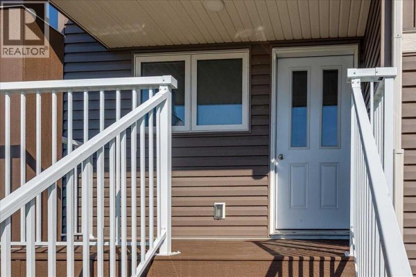 Empty bedroom with beige carpet and a large window with a green view. - 10 Memorial Parkway, Rural Red Deer County