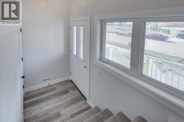 Closet with double doors in an empty room with white walls and grey carpet. - 10 Memorial Parkway, Rural Red Deer County