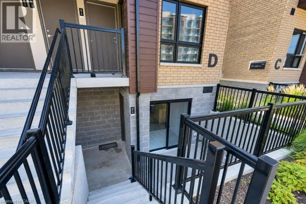Exterior stairs leading down to a lower-level entrance with brick building. - 10 Palace Street Unit# D16, Kitchener