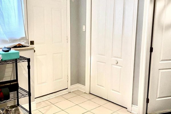 Mudroom entrance with tiled floor, white doors, and a black wire shelving unit. - 10 Parkdene Court, Toronto
