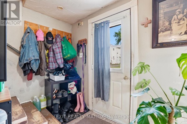 Interior entryway with a coat rack, shoe rack, and a door leading outside. - 10 Peter Street, Champlain