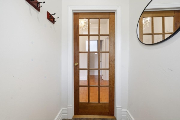 Interior view of a glass paneled wooden door leading to a hallway with wood floors. - 10 Rue De Carillon, Gatineau
