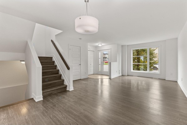Interior view of an open-concept living space showing stairs, entry, and living area. - 10 Rue De L'empire, Gatineau