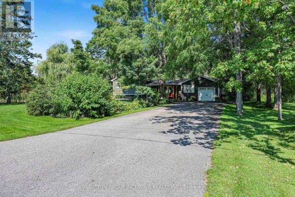 Covered wooden front porch with red seating, a glass-top coffee table, and a small black wood stove. - 10 Springhome Road, Oro Medonte