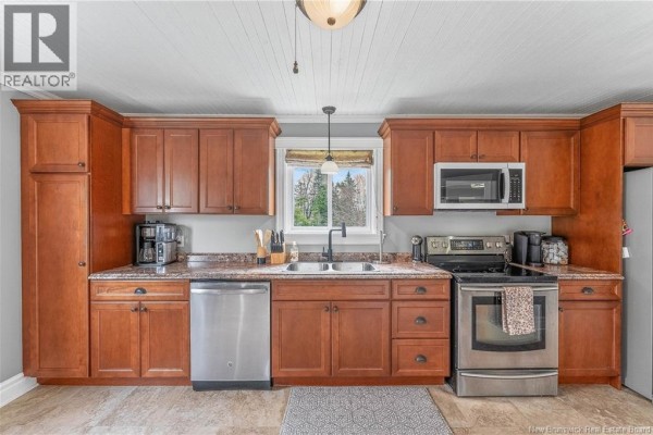 Wide view of a kitchen showing ample storage with dark wood cabinets and modern appliances. - 10 Stanley Oliver Road, Back Bay