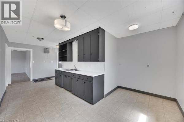View of a kitchen area with dark cabinets and doors leading to other rooms. - 10 Venison Street W, Tillsonburg