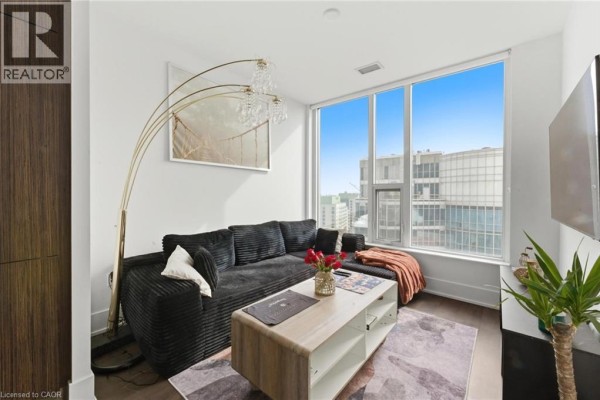Cozy living area featuring a curved floor lamp and large windows with city views - 10 York Street Unit# 3807, Toronto
