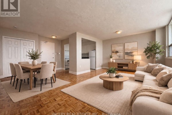 A dining area with a wooden table and chairs opens into a living room with a sectional sofa. - 100 - 890 Jane Street, Toronto