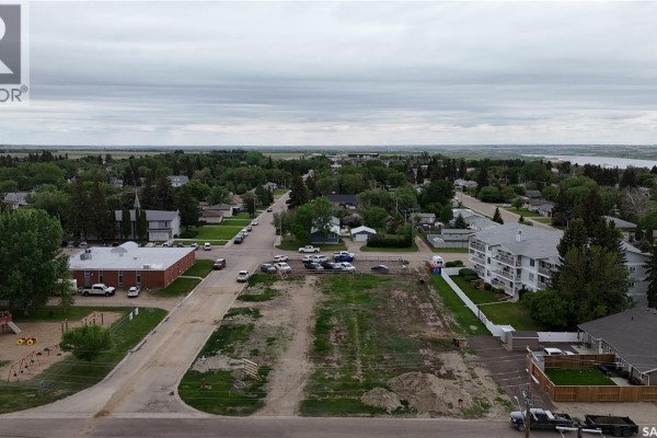Ground-level view of 100-102 Thomson lot, featuring snow, grass, and nearby structures. - 100-102 Thomson Street, Outlook
