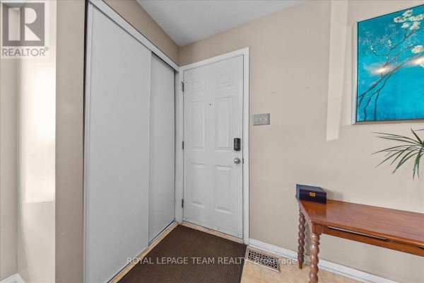Interior entrance with white door, sliding closet doors, and a small console table. - 100 Bonfield Private, Ottawa