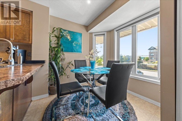 Dining area with a glass table, black chairs, bay window, and view of the street. - 100 Bonfield Private, Ottawa