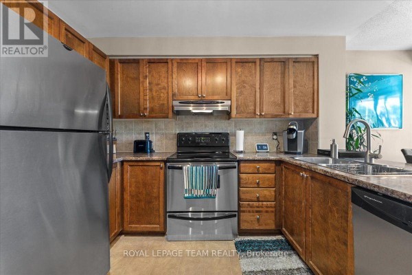 Kitchen features wooden cabinets, stainless steel appliances including a refrigerator and stove. - 100 Bonfield Private, Ottawa