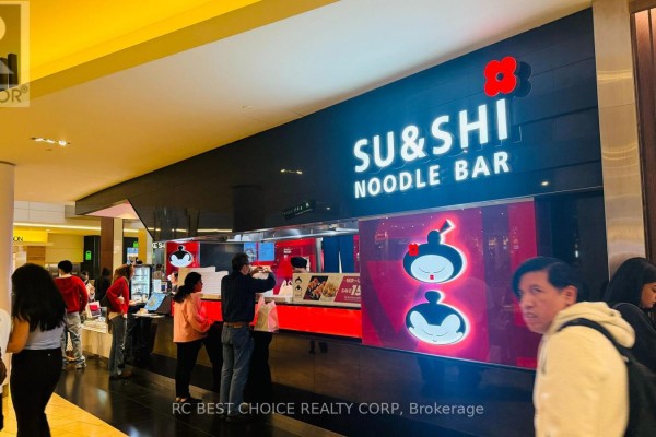 A sushi and noodle bar with a black facade, illuminated sign, and cartoon character artwork. - 100 City Centre Drive, Mississauga