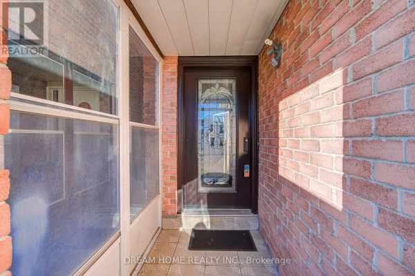 Covered front entryway with brick walls, a glass-paned front door, and a window. - 100 Douglas Haig Drive, Markham