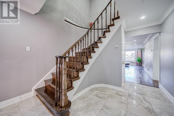 Interior view of a grand staircase with dark wood railing and grey walls. - 100 Douglas Haig Drive, Markham
