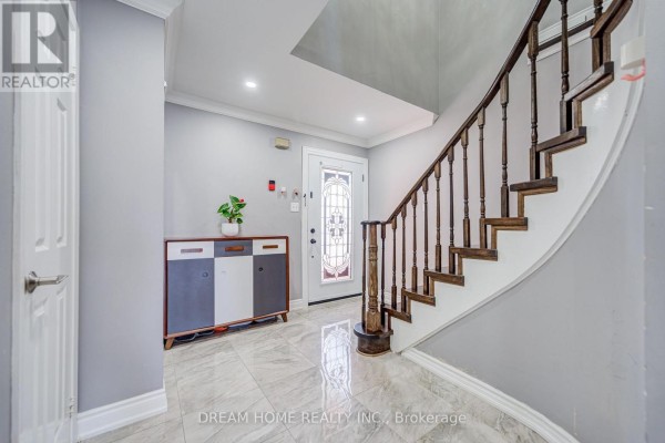 Foyer with a white front door, a dark wood staircase, and grey walls. - 100 Douglas Haig Drive, Markham
