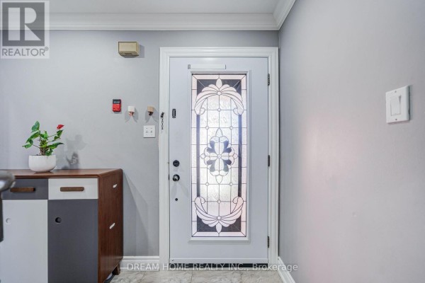 Close-up of the white front door with decorative glass inserts and a console table. - 100 Douglas Haig Drive, Markham