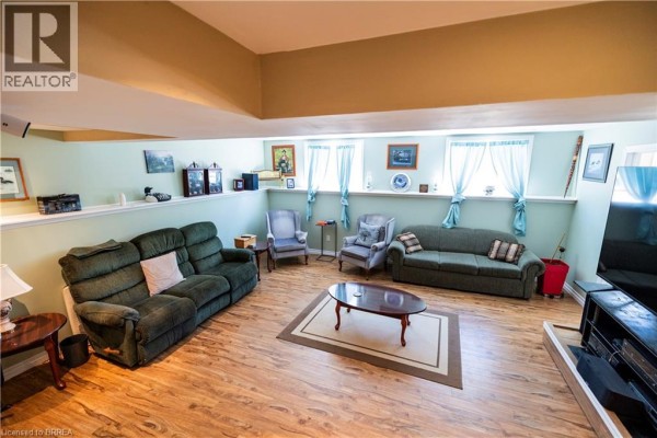 Living room with green sofas, armchairs, coffee table, and vaulted ceiling - 100 Mechanic Street W Waterford