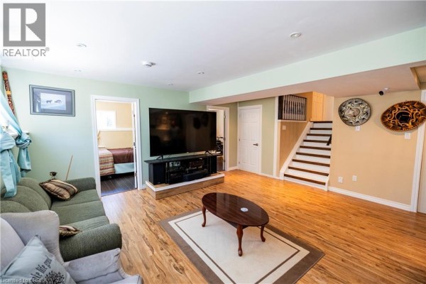 Basement living room with sofa, TV, and stairs - 100 Mechanic Street W Waterford