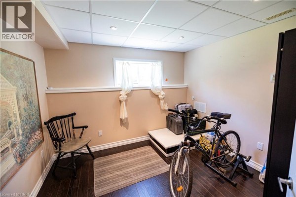 Basement room with bicycle, luggage, chair, rug, and artwork - 100 Mechanic Street W Waterford
