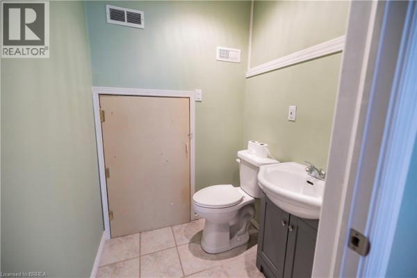 Bathroom with toilet, sink, vanity, and opaque door - 100 Mechanic Street W Waterford