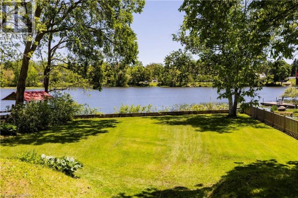 Waterfront yard with lawn, trees, dock, and boathouse - 100 Mechanic Street W Waterford