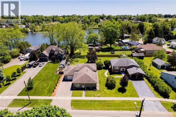 Aerial view of houses, yards, and a lake under a bright blue sky. - 100 Mechanic Street W, Waterford