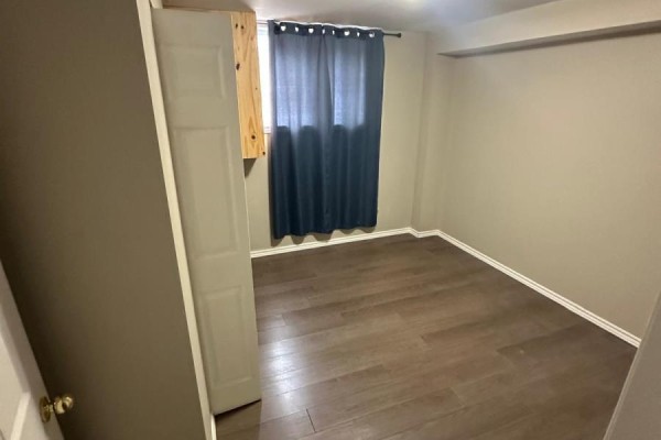 Bedroom with dark hardwood floors and blue curtains - 100 Southview Court Woodstock