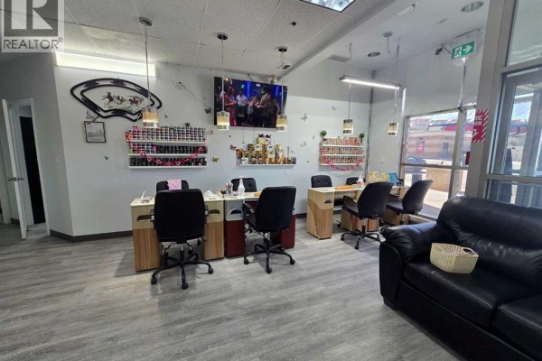 Manicure stations with black chairs and polish displays on a white wall. - 1000 Hamptons Drive Nw, Calgary