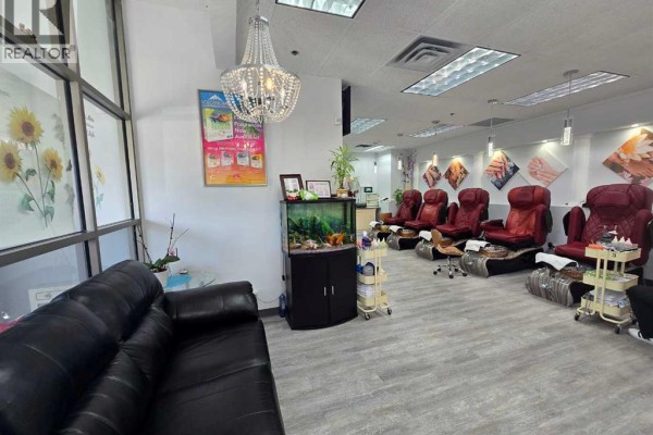 Pedicure chairs in a row, with a black leather sofa and reception area. - 1000 Hamptons Drive Nw, Calgary