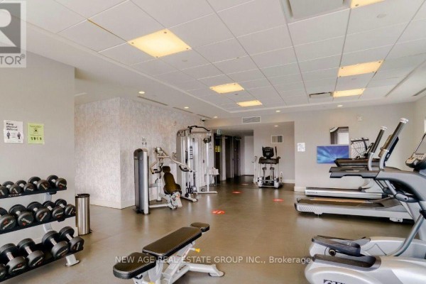 Empty room with white walls, dark wood flooring, and sliding glass doors. - 1001 - 2560 Eglinton Avenue, Mississauga