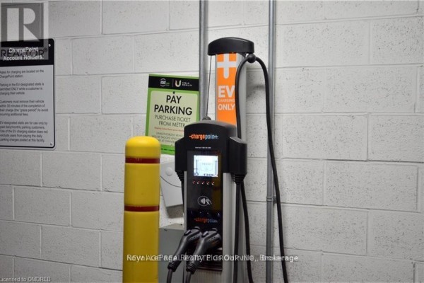 Electric vehicle charging station with two charging ports and signage in a garage. - 1001 - 2560 Eglinton Avenue, Mississauga