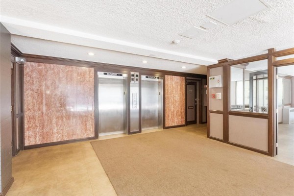 Elevator lobby with three stainless steel elevators, marble walls, and carpet. - 1001 246 Roslyn Road, Winnipeg