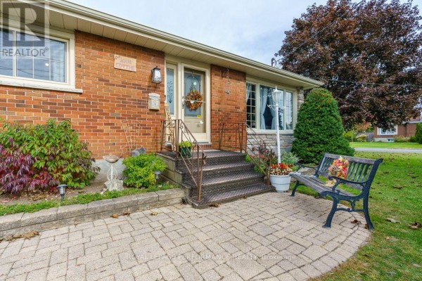 Front entrance with brick walkway, metal stairs, and decorative bench. - 1001 Edythe Avenue, Cornwall