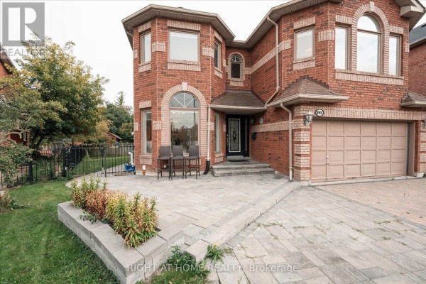 Close-up of the front entrance of a brick house with a paved walkway. - 1001 Lytton Court, Pickering
