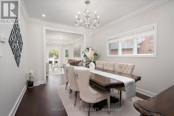 Formal dining room with a dark wood table, upholstered chairs, and a crystal chandelier. - 1001 Lytton Court, Pickering