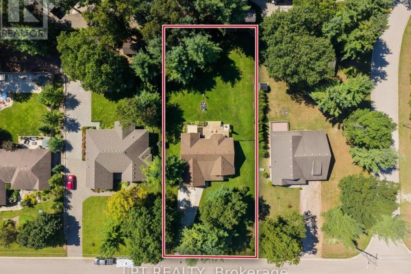 Aerial view of a rectangular property with a house, backyard, deck, and mature trees. - 10011 Jenna Road, Lambton Shores